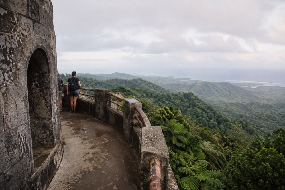 A stone observation tower overlooking layered green rainforest ridges