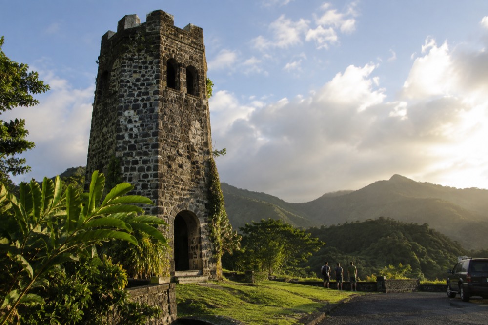 Stone masonry tower overlooking green mountain ridges