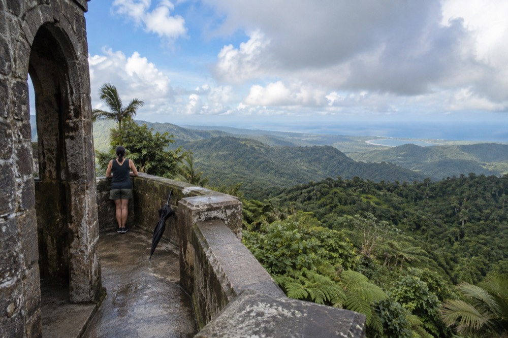 A stone observation tower overlooking layered green rainforest ridges