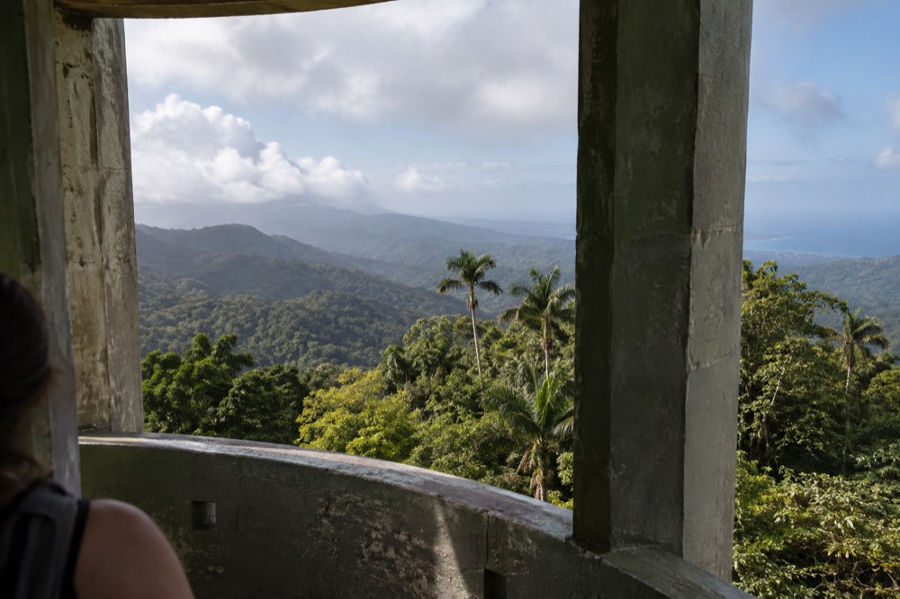 Observation deck of Yokahú Tower looking across a forested ridge with distant clouds